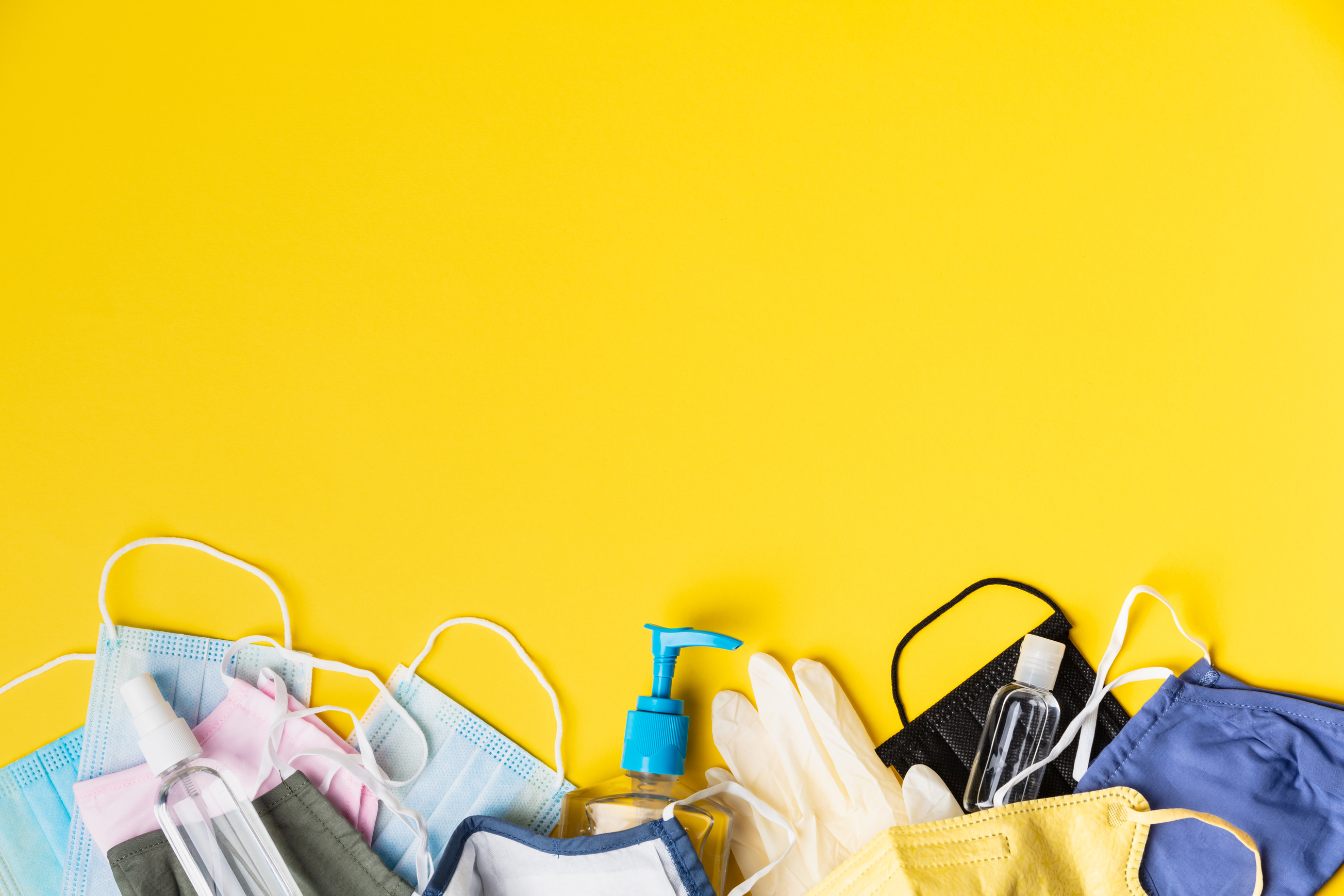 Face Masks, Gloves, and Hand Sanitizer on Yellow Background